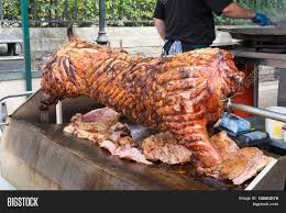 Rotisserie is a style of roasting where meat is skewered on a spit, a long solid rod used to hold food while it is being cooked over a fire in a fireplace or over a campfire. Spit Roasting Pork Image Photo Free Trial Bigstock