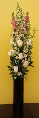 A Vertical Arrangement Larkspur Roses Ruscus More Flower Arrangements Flowers Flower Designs