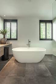zwarte shutters in moderne badkamer solid surface bad en betonlook tegels badkamer modern badkamer badkamer ramen