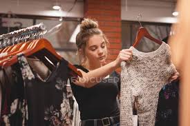 What are these even for? Beautiful Girl Selecting Clothes From Rack In Shopping Mall Variation Lifestyle Stock Photo 209032208