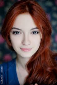 Портрет рыжеволосой девушки на фоне цветной стены Stock Photo