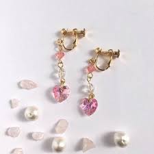 キラキラ輝くスワロフスキーの三連イヤリング 下のスワロフスキーはハート型になっております 淡いお色と高級感ある輝きで 可愛らしさと女性らしさを兼ね備えたイヤリングとなっています カラー ピンク サイズ 約4 4ｃｍ 1ｃｍ 金具含む 素材 スワロフスキー