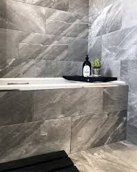 In this refined bathroom created by designyyz, the small marble tile inserted within a large slate tile floor lengthens the space and provides a nice focal point. Top 60 Best Grey Bathroom Tile Ideas Neutral Interior Designs