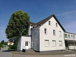 weisses altes haus mit anbau vor blauem himmel in helpup bei oerlinghausen im teutoburger wald in ostwestfalen lippe teutoburger wald blauer himmel altes haus