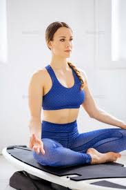 Young Woman Doing A Surf Yoga Lotus Pose In 2020 Lotus Pose Lotus Yoga Poses
