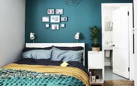 Ein Schlafzimmer Mit Dunkelgrunen Wanden Und Bunter Bettwasche Kleines Schlafzimmer Einrichten Schlafzimmer Einrichten Kleines Schlafzimmer
