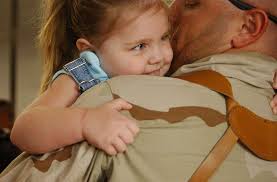 Gunner's Mate 1st Class John L. Tatro, assigned to U.S. Navy Cargo Handling  Battalion One (NCHB-1) kisses his daughter after returning to Naval Station  Norfolk.