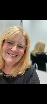 What hairstyle suits a 53-year-old woman with a round face to look younger?