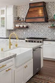 A White Island Is Fitted With A Kitchenaid Dishwasher And A Farmhouse Sink With A Gold Goosene Kitchen Backsplash Designs Diy Kitchen Backsplash Simple Kitchen