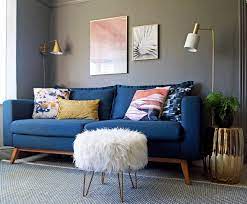 Grey is a better pair for the dark blue wall because choosing a sofa in a dark blue tone, in this case, will only make it lost in the interior design. Living Room Design Blue Sofa Grey Walls And Accents In Pink White And Gold First Sense In Blue Living Room Decor Blue Sofa Living Blue Sofas Living Room