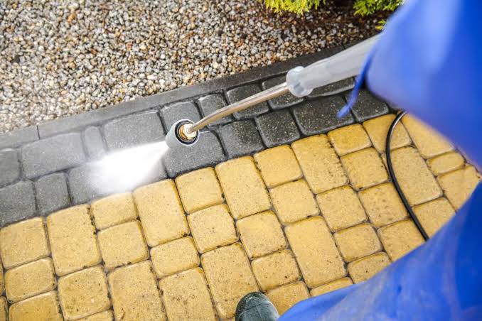 Pressure washing carefully before refreshing the sand joints., AI generated