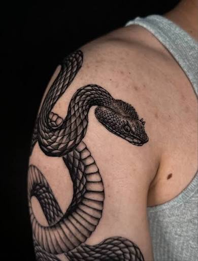This black and grey snake tattoo by @vic.ink_ 🌹is sharply executed with precise, well-defined scales and smooth shading that adds depth🐍Its dynamic coiled movement flows naturally with the arm's shape, making the