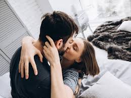 Romantic couple reuniting after a breakup, embracing in a bedroom setting.
