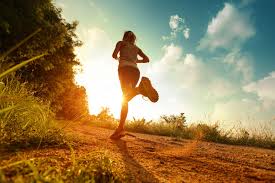 The image shows us a person running along a path at sunset.