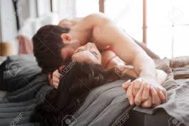 Apaixonado Sexy Jovem Casal Deitado Na Cama No Quarto. Ele Está Acima E  Beijo Modelo. Casal Segurar A Mão Na Mão. Eles Gostam De Momento. Foto  Royalty Free, Gravuras, Imagens e Banco