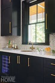 In a kitchen designed by soler architecture and design, black and white cabinets are set off with black marble countertops. Galleries New England Home Magazine