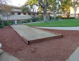A typical bocce court has a wooden border, a rocky drainage layer, and a playing surface. Gold Oyster Shell Bocce Court Expertise Low Prices Fast Delivery