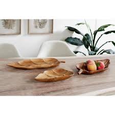 Whether you're looking to serve guests, enjoy coffee and a good book in bed, or an accent piece for the coffee table this serving tray or lazy susan. Litton Lane Large Rustic Leaf Shaped Natural Teak Wood Serving Trays Set Of 3 66076 The Home Depot
