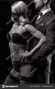 Man in tuxedo holdinng sexy woman in underwear at night bdsm bla Stock  Photo by ©sakkmesterke 329023720