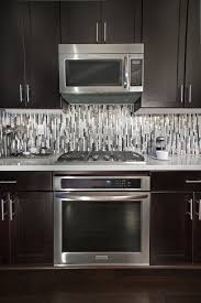 To Accentuate The Modern Lines Within We Laid The Quartz Metal And Glass Backsplash Modern Kitchen Backsplash Kitchen Tiles Backsplash Glass Tile Backsplash