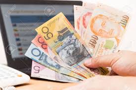 Hand Sorting Australian Dollar And Singapore Dollar In Front
