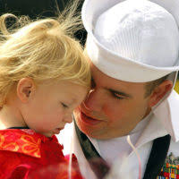 A little boy is pinned as the Navy's newest honorary SEAL by two elite Navy  SEALs after a grueling workout. SEALs assigned to Naval Special Warfare  Group (NSWG) 2 hosted the little