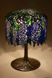 The artistic blend of sculpture and function in the wisteria lamp, in which the base rises up to form the branches. Wisteria Lamp Tiffany Wisteria Tiffany Lamps Tiffany Style Lamp