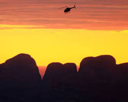 Uluru's silhouette against the backdrop of a sunset