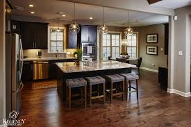 Regency Homebuilders Open Concept Living Open Kitchen Pendant Lighting Recessed Lighting Dark Kitchen Cabinets Trendy Kitchen Tile Yellow Kitchen Accents