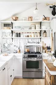 Mullioned windows take residence above the white farmhouse sink, wedged between black kitchen cabinets and gold hardware. 30 Best White Kitchens Photos Of White Kitchen Design Ideas
