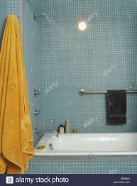 Ein Modernes Badezimmer Fliesen Wande Mit Mosaik Fliesen Bad Verchromte Armaturen Handtuchhalter Orange Handtuch Tippen Stockfotografie Alamy