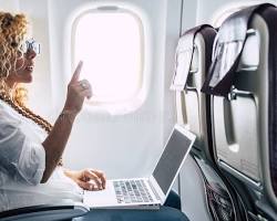 airplane cabin with a person using a laptop connected to WiFiの画像