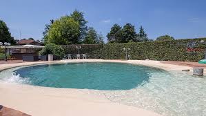 Naturpool und kleine holzterrasse mit sonnenliegen. Strand Pools Pools Mit Strandeinstieg Renolit Alkorplan Die Weltweit Fuhrende Gewebeverstarkte Abdichtungsbahn Zur Auskleidung Von Schwimmbadern