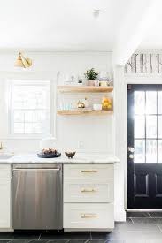 I'm replacing a cabinet in my kitchen with three floating shelves. White And Gold Kitchen Features White Shaker Cabinets Adorned With Brass Pulls Paired With Calcutta Marble Co Contemporary Kitchen Home Kitchens Kitchen Design