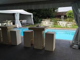 een sfeerimpressie van een ingerichte tent naast het zwembad met krukken en statafels te huur bij van rijswijk verhuur in gender tent zwembad tuinarchitectuur