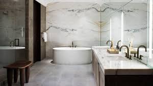 The rough brick wall and unfinished wood table of this space contrast with the smooth, geometrical look of the washbasin and mirror. 27 Exquisite Marble Bathroom Design Ideas