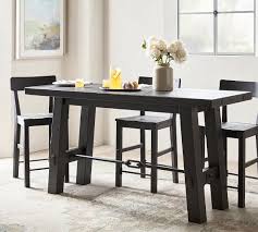 For storage, get a counter height dining room set with a rectangular centerpiece that has shelving, cubbies, or a wine rack. Benchwright Counter Height Table Pottery Barn