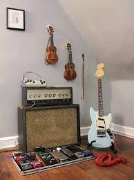 The guitar is made of wood with metal strings and accents creating a rustic and industrial look. Music Room Guitar Fender Guitar Guitar Room Cool Guitar