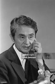 L.A. Coroner Thomas Noguchi points to his left cheek showing where... News  Photo