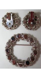 Hermoso broche y aretes circulares de diamantes de imitación ahumados