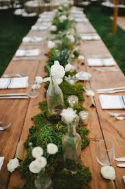 Moss Table Runner Decorated With White Flowers Bottle Vases And Candles Moss Wedding Wedding Table Flowers Romantic Backyard