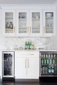This White Butlers Pantry With Shaker Cabinets Displays Long Brass Pulls Under Cabinet Lighting And Horizontal Marbl Kitchen Remodel Home Kitchens New Kitchen