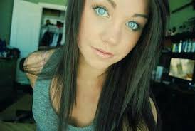 The woman has blue eyes and long dark curly hair that lighly covers half. Brown Haired Girl With Blue Eyes On We Heart It