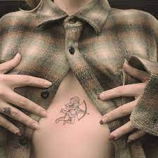 A Small Cupid Tattoo On The Sternum Cupid Tattoo Tattoos Creepy Tattoos