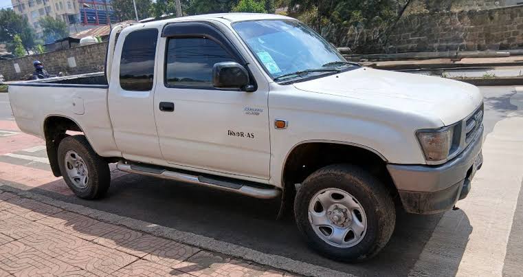 The rugged exterior profile of this classic white 2004 Toyota Hilux N170 series., AI generated