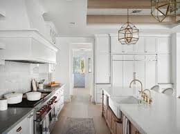 The black granite counters look beautiful on both center island and peninsula. White Kitchen With Brown Oak Island Transitional Kitchen