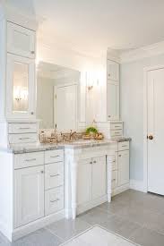 Chic Bathroom Features Ceiling Height Cabinets With Mirrored Doors Flanking Framed Mirror Over Mirrored Cabinet Doors Bathroom Cabinets Designs Chic Bathrooms