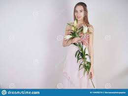The lush lily is a small, well stocked florist that has some lovely flowers. Charming Young Caucasian Girl In A Pretty Dress Holds A Lush Lily Flower In Her Hands And Stands On A White Background In The Stud Stock Photo 144656270 Megapixl
