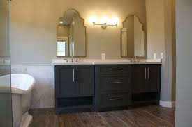 Custom floating vanity with round vessel sink and complemented by circular mirror design. Valley Custom Cabinets Bathroom Vanity
