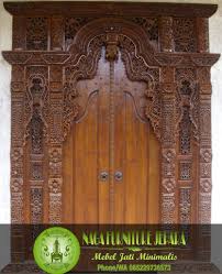 Pintu garasi berikutnya, terbuat dari panel kayu dan diimbangi dengan batu bata di sekelilingnya. Konsep Terkini 21 Pintu Ukiran Bali Minimalis